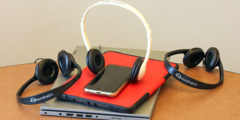 A cell phone and headphones on a computer
