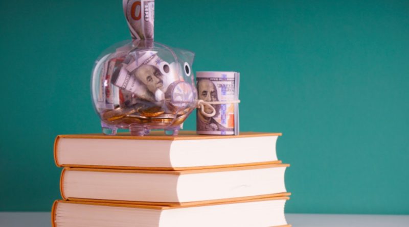 A stack of books and a piggy bank with money